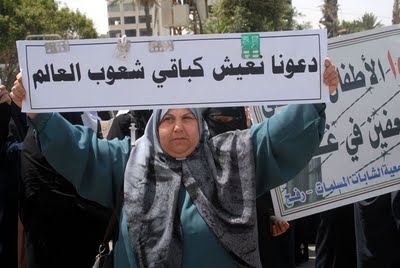 13.4.2010, www.paldf.net, biarkan kami hidup seperti masyarakat dunia lainnya, 3 Seorang perempuan Palestina mengangkat poster bertuliskan: "Biarkan kami hidup sebagaimana masyarakat dunia lainnya!" (foto: www.paldf.net)
