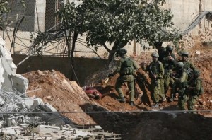 Tubuh salah seorang syahid Palestina di dekat reruntuhan rumah Tubuh Al-Karami di dekat rumah yang diruntuhkan oleh tentara Zionis