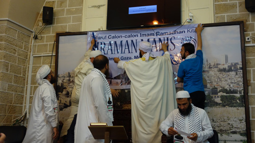 Syeikh 'Ahid Zino, Imam Masjid 'Umari Al-Kabir, memasang sendiri spanduk SIRAMAN MANIS. foto: Sahabat Al-Aqsha