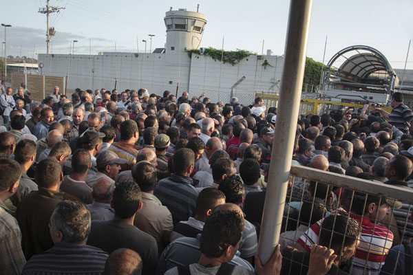 Matahari telah terbit sempurna dan kerumunan warga Palestina masih mengantri untuk masuk ke pos pemeriksaan Eyal. Selama berjam-jam ke depan kerumunan besar masih akan memenuhi Eyal. foto: Daniel Tepper/Electronic Intifada