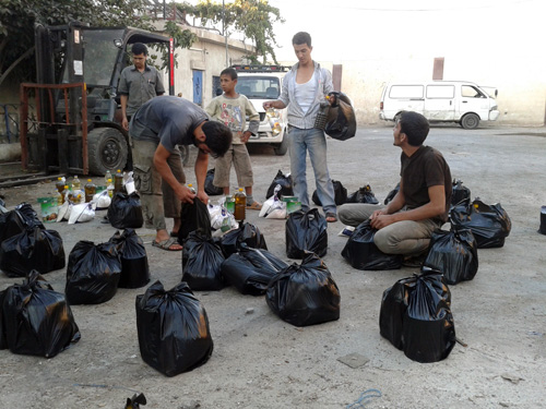 Membagikan sembako kepada orang kesusahanpun mengandung risiko, ketika angkara murka sedang mengamuk. Remaja-remaja ini ambil risiki membantu kita. foto: Sahabat Suriah/Sahabat Al-Aqsha/Radio Rodja/HALUAN/Al-Sarraa