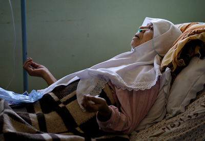 Seorang ibu pasien Gaza mengangkat tangan berdoa dan berharap hanya kepada Allah. foto: Photo Shelter/Jeffrey