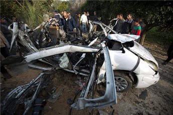 Warga mengelilingi mobil dua mujahid Gaza yang dibom Zionis pada Rabu (22/1). Foto: AFP/Ma'an