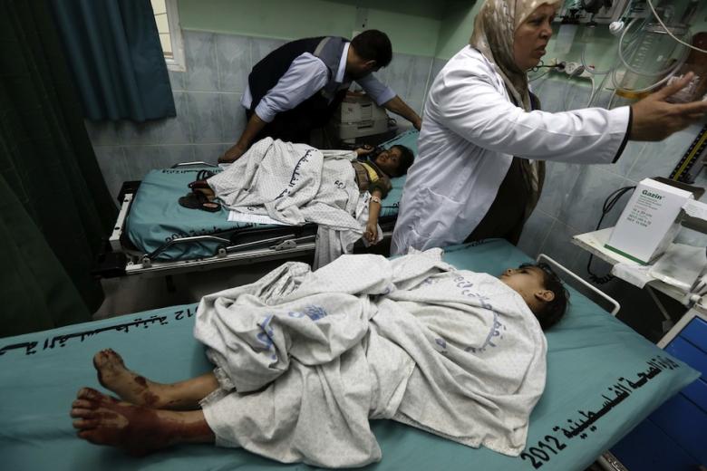 Dokter Palestina sedang menangani anak yang terluka karena serangan udara penjajah zionis 'Israel' di Beit Lahia, utara Jalur Gaza pada 23 April 2014. Foto: AFP 