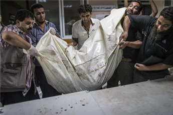 Para relawan Palestina mengangkat kantung berisi jenazah anak-anak di RS Shifa, Gaza. Foto: AFP