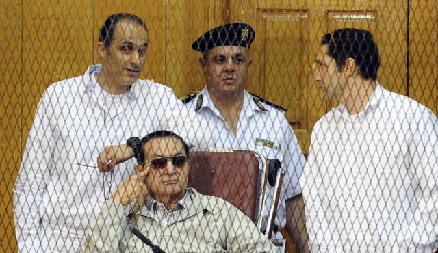 Husni Mubarak (posisi duduk), diapit kedua anaknya, saat sedang proses pengadilan tahun 2013. Foto: Haaretz