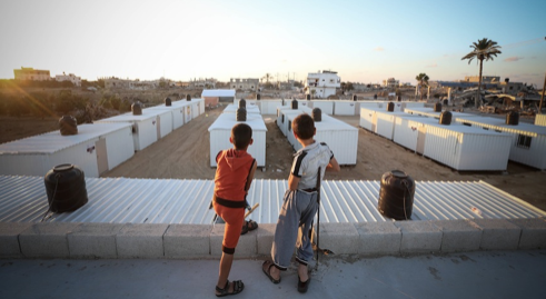 Anak-anak melihat pemandangan dari atas salah satu pemukiman caravan trailers di Khuza'a, 22 September 2014.