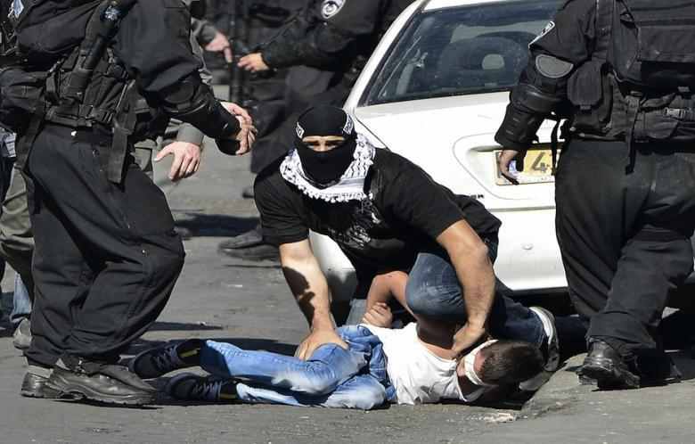 Pasukan zionis, termasuk pasukan yang menyamar sebagai warga Palestina, menahan paksa seorang anak Palestina di Al-Quds Terjajah pada 24 Oktober 2014. Foto: Salih Zeki Fazl?o?lu  