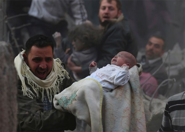 Seorang bocah Suriah diselamatkan dari reruntuhan. Foto: Middle East Monitor