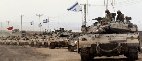 Tank Zionis Merkava melaju di dekat perbatasan antara ‘Israel’ dan Jalur Gaza saat mereka kembali dari kawasan pantai Palestina yang berada di bawah kekuasaan Hamas pada 5 Agustus 2014, setelah ‘Israel’ mengumumkan bahwa seluruh pasukan menarik diri dari Jalur Gaza. Zionis menyelesaikan penarikan mundur seluruh pasukannya dari Gaza ketika gencatan senjata kemanusiaan selama 72 jam diberlakukan menyusul kuatnya tekanan global untuk mengakhiri konflik berdarah di Gaza. Foto: Thomas Coex/AFP/Getty Images