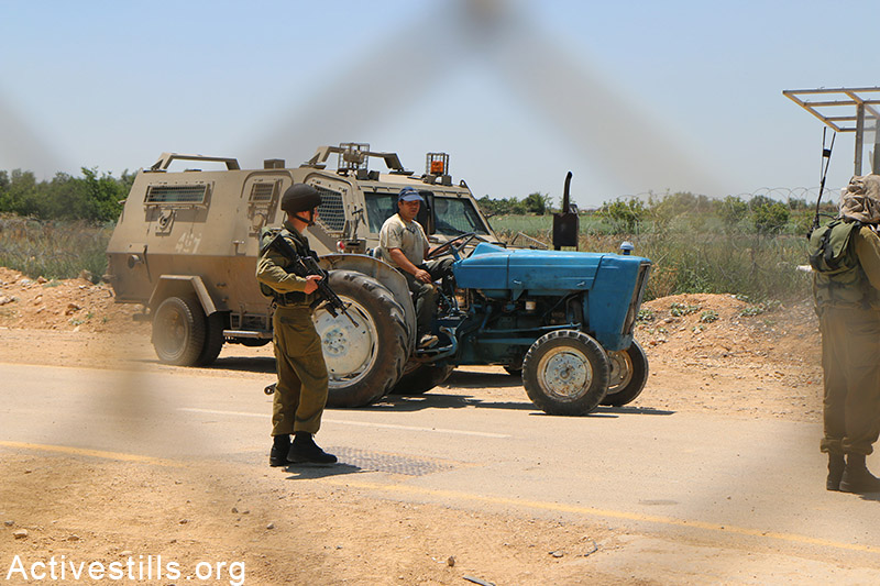 Petani Palestina mengendarai traktornya di sebelah barat pagar pemisah di desa Falamya. Foto: Ahmad al-Bazz/Activestills.org