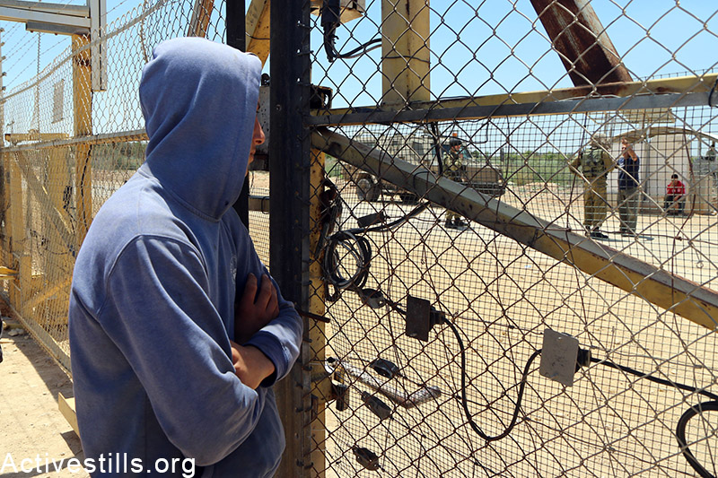 Petani Palestina berdiri di samping gerbang lahan pertanian di pagar pemisah dekat desa Falamya. Foto: Ahmad al-Bazz/Activestills.org