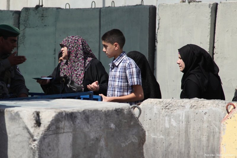 Seorang wanita berdebat dengan serdadu Zionis karena ia tak diizinkan melintas lewat Qalandiya. Foto: Rich Wiles