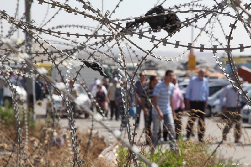 Para lelaki Palestina berjalan menuju pos khusus pria di Qalandiya. Foto: Rich Wiles