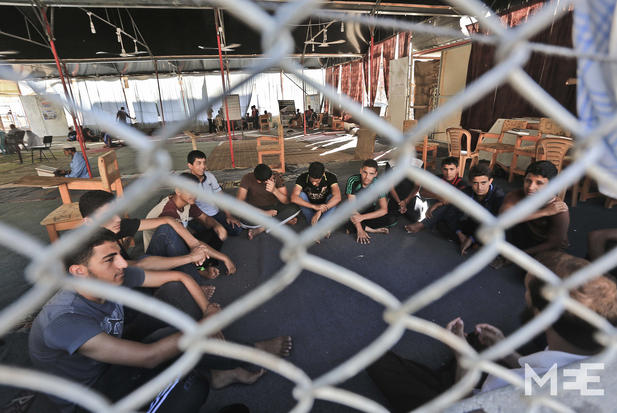 Sekelompok pria Gaza sedang membaca Al-Quran di masjid yang dihancurkan F16 Zionis pada perang tahun lalu. Foto: MEE/Mohammed Asad