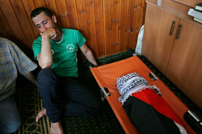 Seorang kerabat keluarga Dawabsheh, duduk di samping jenazah Ali Saad Dawabsheh (18 bulan), yang tewas terpanggang di rumah keluarganya di desa Duma, Tepi Barat terjajah, 31 Juli lalu. Foto: Ahmad Talat/APA images