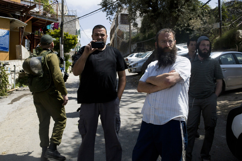 Para pemukim ilegal Yahudi, di antara mereka ada Baruch Marzel, berdiri di pintu masuk kawasan Tel Rumeida pada April 2014. Foto: Keren Manor/ActiveStills 