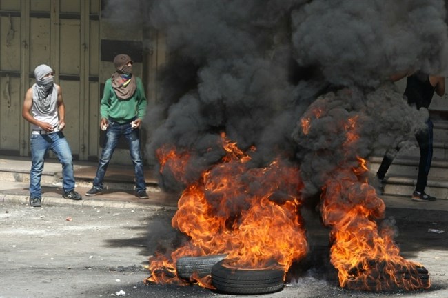 Para pendemo melemparkan batu dan membakar dalam sebuah demonstrasi di Al-Khalil, 29 September 2015. Foto: AFP/Hazem Bader