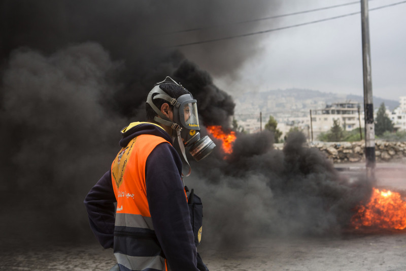 Seorang tenaga medis Palestina menggunakan masker gas airmata. Kebanyakan tenaga medis itu merupakan relawan. Foto: Anne Paq