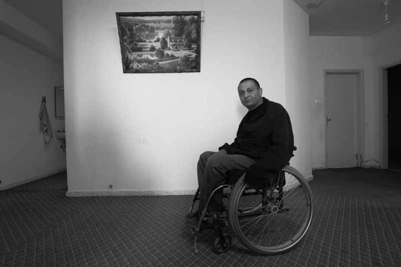 Peluru yang menerjang Kamal Abdeen melintasi tenggorokannya saat ia berbalik ke arah Goldstein. Ia sempat koma selama empat bulan sebelum akhirnya sadar, namun tetap lumpuh dari dada ke bawah. “Serdadu selalu menggeledah kami sebelum memasuki masjid dan kami harus melewati detektor logam,” katanya. “Hari itu mesin dimatikan dan tidak ada seorang pun yang menggeledah kami. Hanya ada sedikit serdadu, mereka hanya bersantai dan tertawa-tawa. Mereka berpikir tidak seorang pun bisa keluar hidup-hidup.” Foto: Rich Wiles/Al Jazeera 