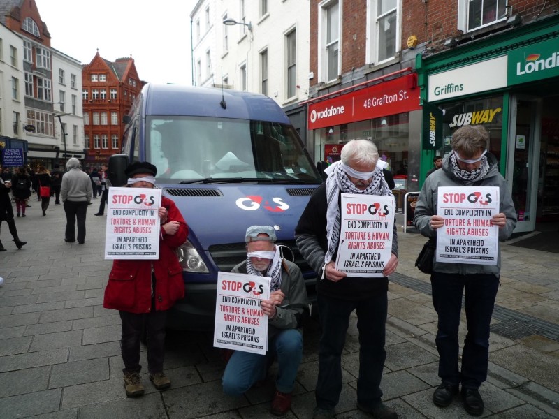 Para relawan Irlandia melakukan pertunjukan teater jalanan, berdiri dengan mata tertutup kain di sekitar mobil van G4S di Dublin, serta membagikan bahan-bahan mengenai peran G4S dalam mendukung penjajahan. Foto: IPSC