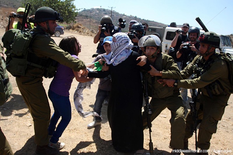 Pasukan Zionis menangkap wanita Palestina yang memprotes perampasan tanah dan perluasan permukiman ilegal Yahudi Halamish. Foto: Middle East Monitor/APA images