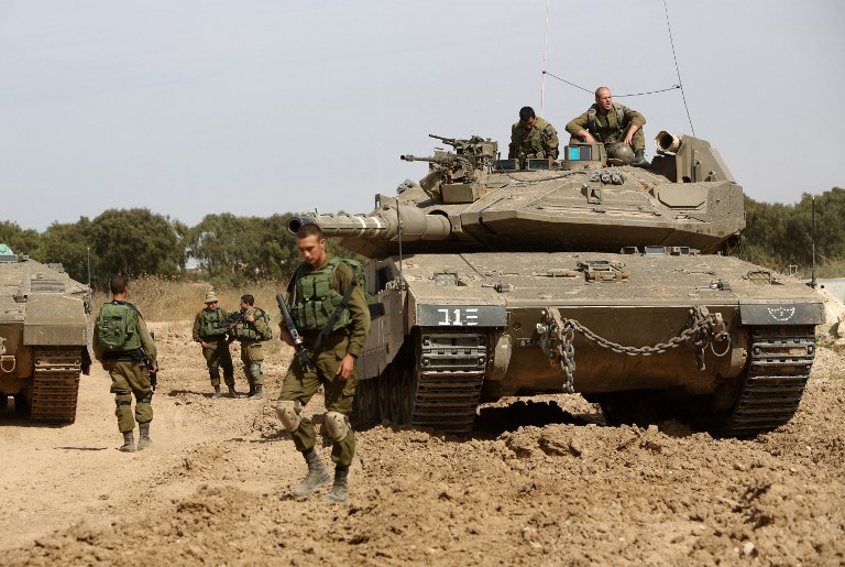Serdadu Zionis berjaga-jaga dengan tank mereka di sepanjang perbatasan antara ‘Israel’ dan Jalur Gaza di dekat sebelah selatan kibbutz ‘Israel’, Nahal Oz pada 4 Mei 2016. Foto: AFP/Menahem Kahana