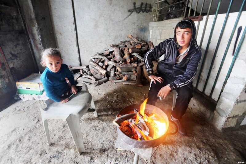 Warga Palestina membakar kayu bakar agar tetap hangat karena kekurangan listrik. Foto: Apaimages