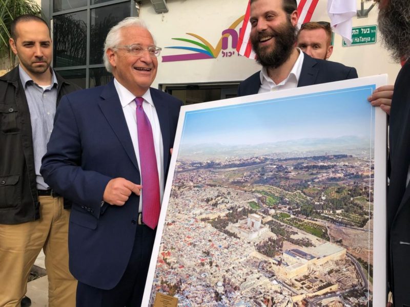 Duta Besar AS David Friedman berdiri di samping gambar kontroversial, 22 Mei 2018. Foto: Israel Cohen/Kikar Hashabat