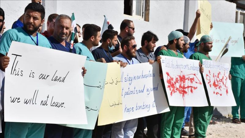 Para demonstran memegang poster saat unjuk rasa menentang serangan yang dilakukan rezim Assad dan sekutu-sekutunya terhadap rumah sakit dan pusat kesehatan di zona de-eskalasi di Idlib, Suriah, pada 16 September 2018. Foto: Muhammed Abdullah/Anadolu Agency 