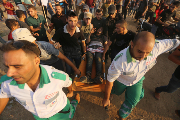 Paramedis Palestina menyelamatkan seorang pria yang terluka ditembak serdadu Zionis di Jalur Gaza. Foto: MEE/Mohammed Asad