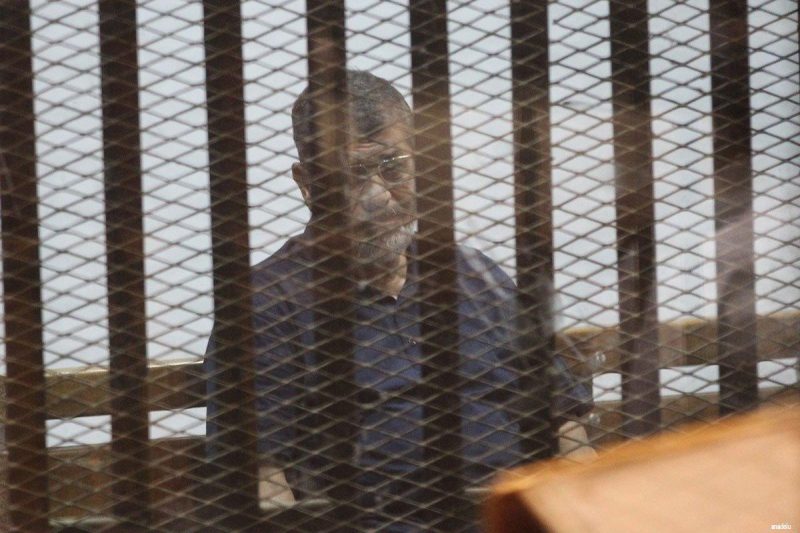 Mantan Presiden Mesir Muhammad Mursi duduk di balik jeruji saat persidangannya pada 26 Februari 2017. Foto: Middle East Monitor