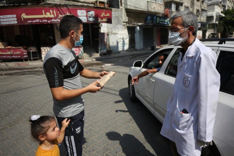 Tim Kementerian Kesehatan menyalurkan obat-obatan kepada para warga yang harus menjalani lockdown guna mengekang Covid-19 di Gaza pada 4 Oktober 2020. Foto: Mohammed Asad/Middle East Monitor