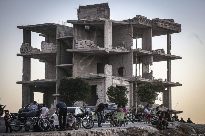 Warga Suriah melanjutkan kehidupan mereka di antara bangunan-bangunan yang rusak akibat peperangan di Idlib, Suriah, pada 14 Agustus 2020 [Muhammed Said / Anadolu Agency] 