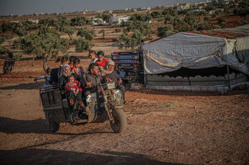 Sejumlah warga Suriah menaiki kendaraan di sebuah kamp di Idlib, Suriah pada 30 Juni 2021. [Muhammed Said/Anadolu Agency]