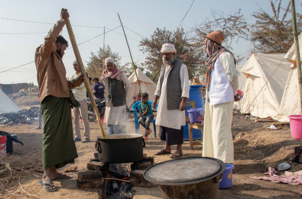 Para Muhajirin sedang mempersiapkan makan di dapur umum yang dibangun lembaga kemanusiaan. Foto: thecitizen.in 