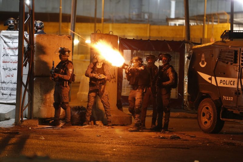Gerombolan serdadu zionis ‘Israel’ menembakkan gas air mata ke arah warga Palestina di Qalandiya, Tepi Barat terjajah, pada 11 Mei 2021. Foto: Abbas Momani/AFP/Getty Images