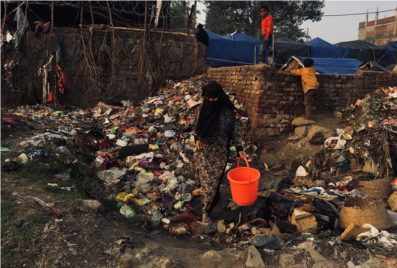 Seorang Muslimah berada di tempat pembuangan. Sumber: Two Circles