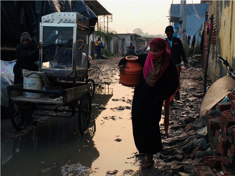 Seorang Muslimah Rohingya membawa gentong plastik berisi air. Foto: Shadab Farooq